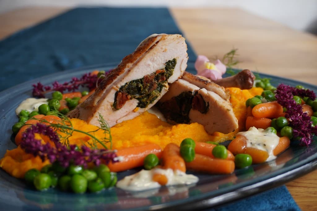 Danie z pieczonego mięsa z farszem, purée warzywnym i sezonowymi dodatkami